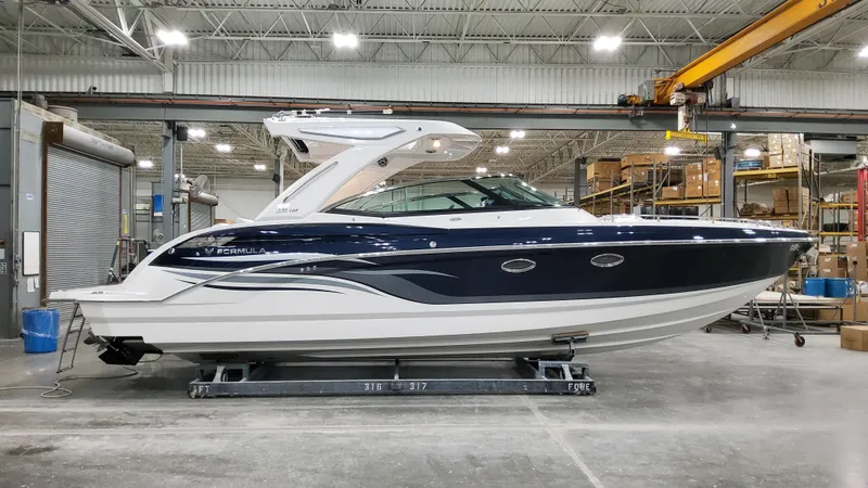 Slide: The Image of 2025 Formula 330 Crossover Bowrider I/O in a showroom, side view. - 6