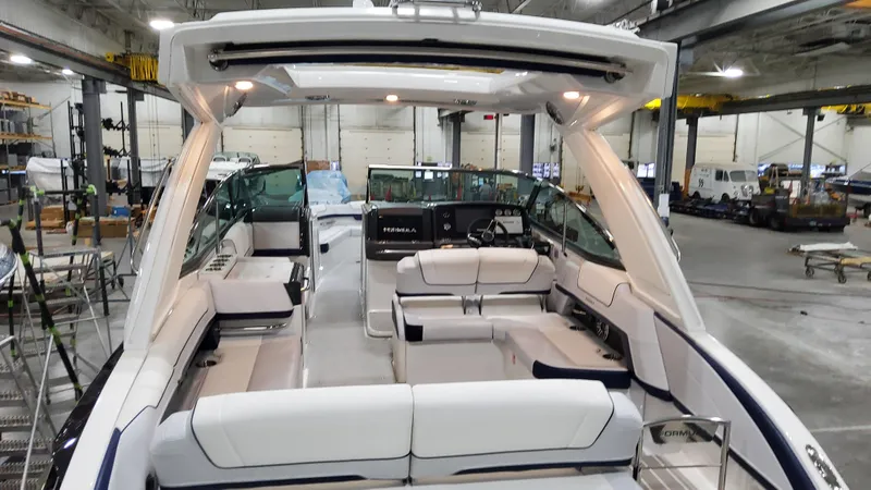 Slide: The Image of 2025 Formula 330 Crossover Bowrider I/O interior in a showroom, showcasing luxury seating. - 8