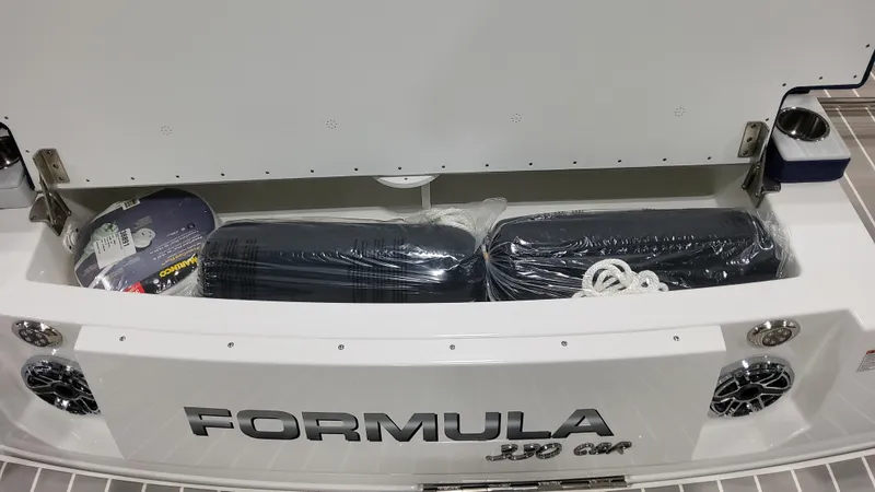 Slide: The Image of 2025 Formula 330 Crossover Bowrider I/O storage compartment with accessories and speakers. - 9