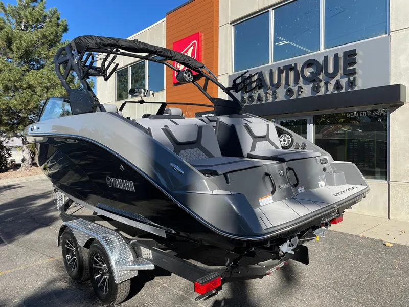 Slide: The Image of 2025 Yamaha Boats 222XD displayed outside dealership, sleek design, dual-axle trailer. - 3