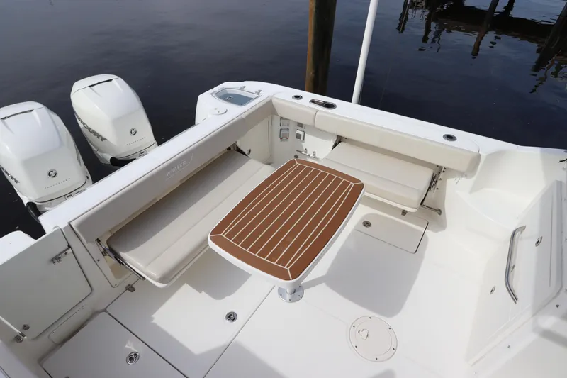 Slide: The Image of 2019 Boston Whaler 315 Conquest boat deck with seating and table. - 15