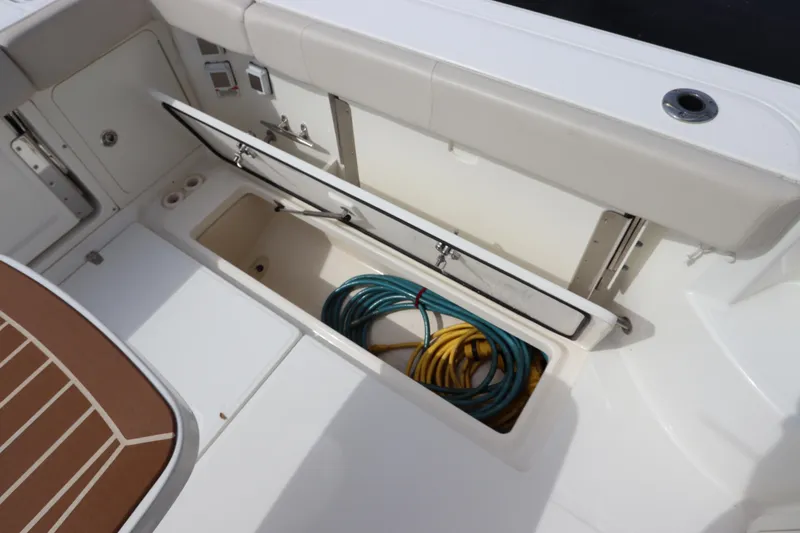 Slide: The Image of 2019 Boston Whaler 315 Conquest deck storage with coiled hoses. - 16