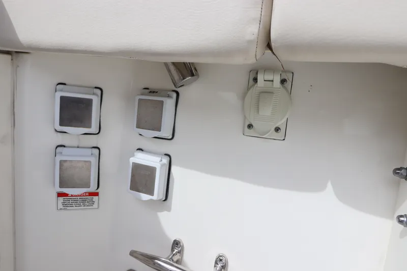 Slide: The Image of 2019 Boston Whaler 315 Conquest boat interior with electrical outlets and switches. - 17