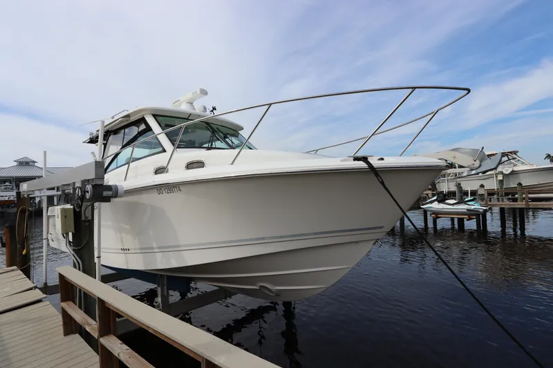 Slide: The Image of 2019 Boston Whaler 315 Conquest boat docked at marina under clear sky. - 2