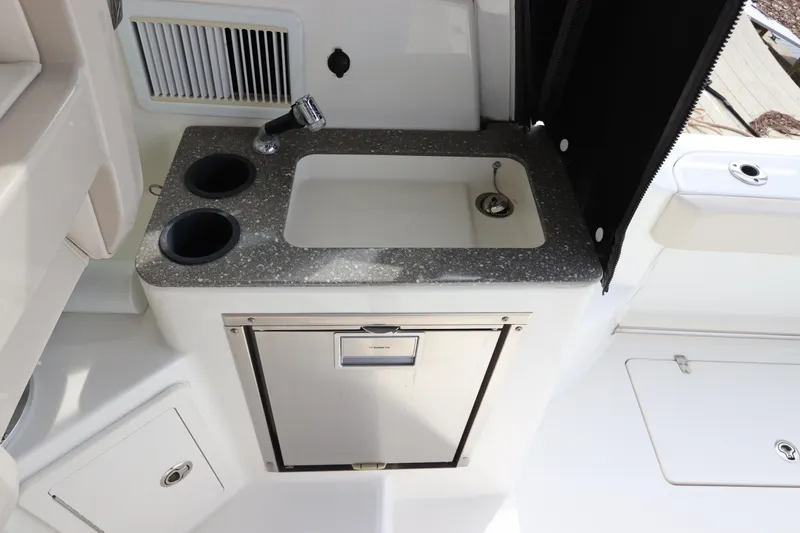 Slide: The Image of 2019 Boston Whaler 315 Conquest boat kitchenette with sink and storage. - 21