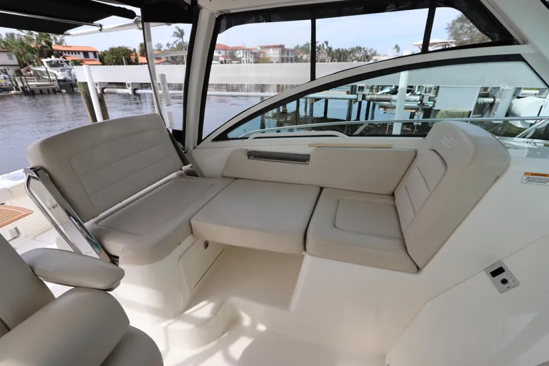 Slide: The Image of 2019 Boston Whaler 315 Conquest interior seating area with waterfront view. - 24