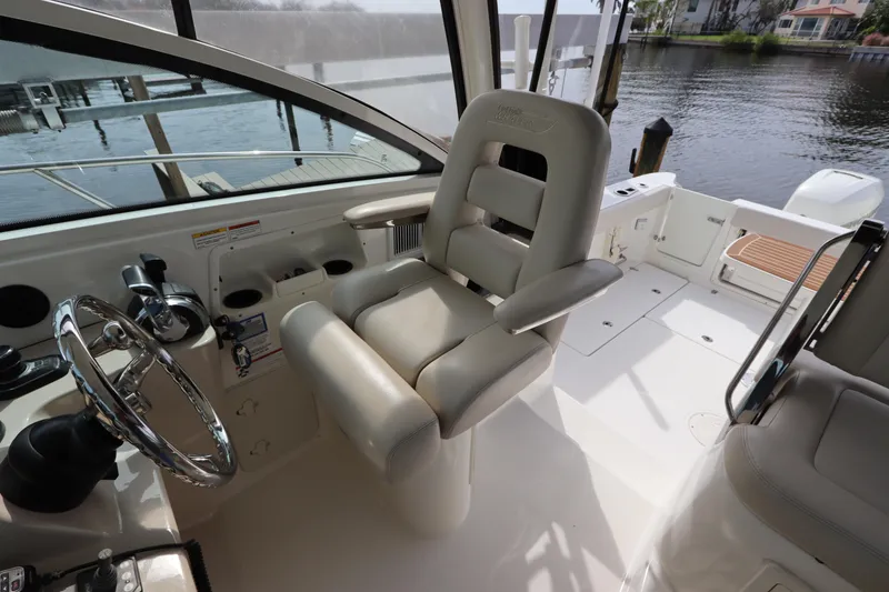 Slide: The Image of Interior of 2019 Boston Whaler 315 Conquest boat with helm seat and controls. - 26