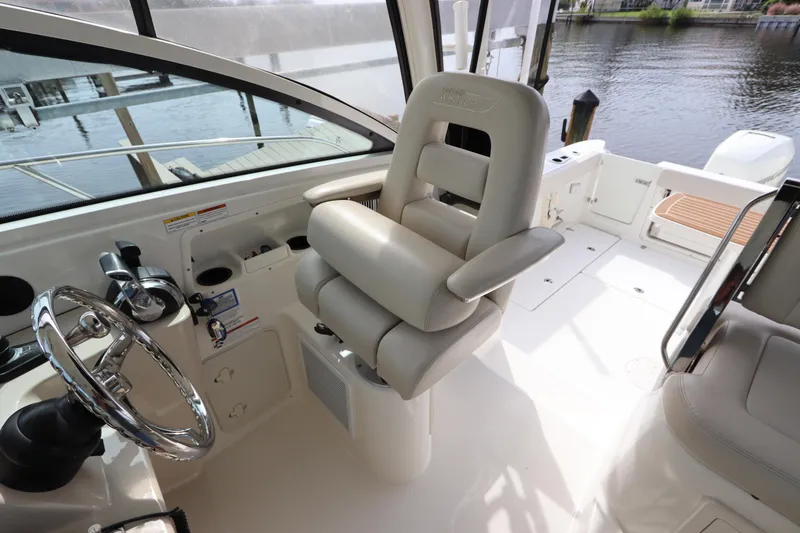 Slide: The Image of 2019 Boston Whaler 315 Conquest helm with plush captain's chair and sleek controls. - 27
