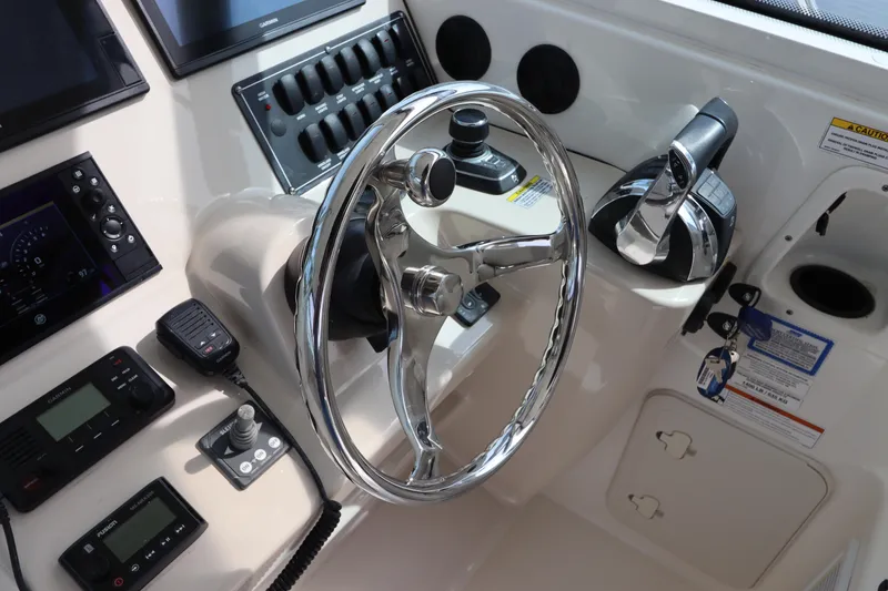 Slide: The Image of 2019 Boston Whaler 315 Conquest helm with steering wheel and control panel. - 33