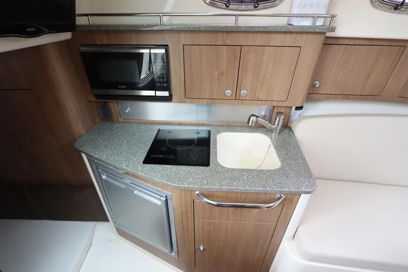 Slide: The Image of 2019 Boston Whaler 315 Conquest boat kitchen with microwave, sink, and compact fridge. - 37
