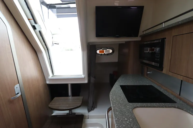 Slide: The Image of Interior of 2019 Boston Whaler 315 Conquest with kitchenette and TV. - 38