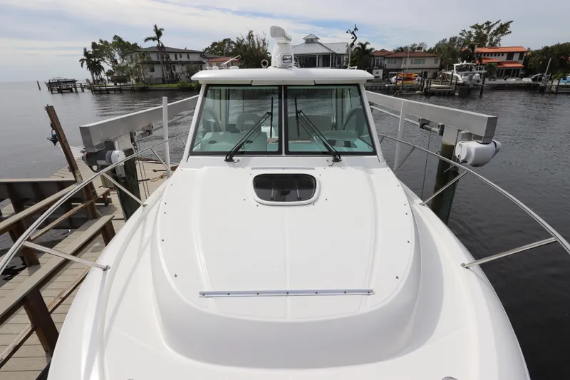 Slide: The Image of 2019 Boston Whaler 315 Conquest docked near waterfront homes. - 6
