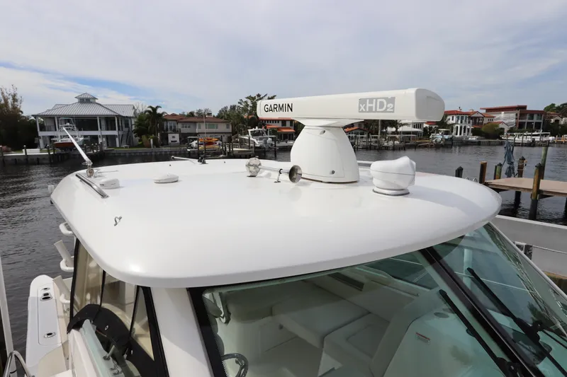 Slide: The Image of 2019 Boston Whaler 315 Conquest with Garmin radar on the roof, docked by waterfront homes. - 7