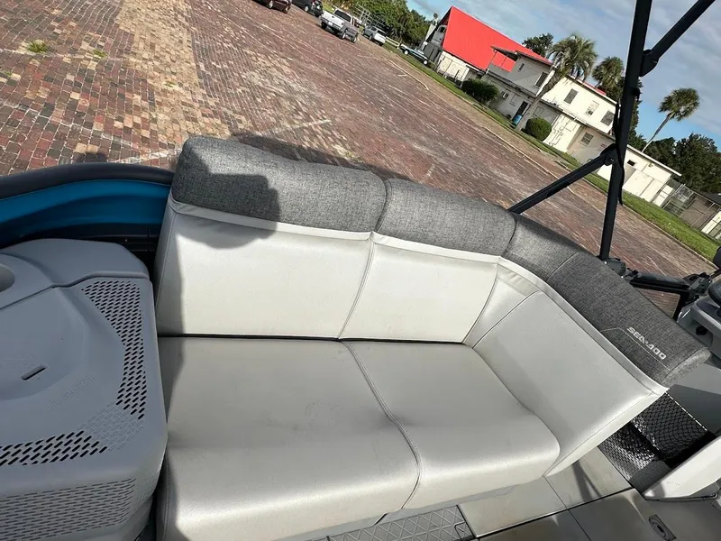Slide: The Image of 2023 Sea-Doo Switch Cruise 21 boat interior with gray seating and outdoor view. - 19