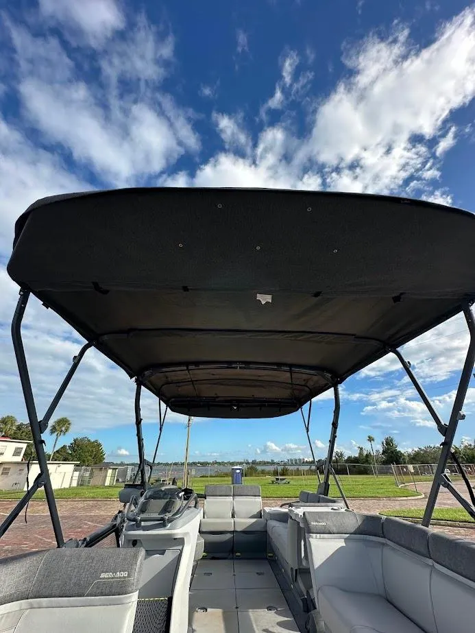 Slide: The Image of 2023 Sea-Doo Switch Cruise 21 pontoon boat with canopy under a blue sky. - 20