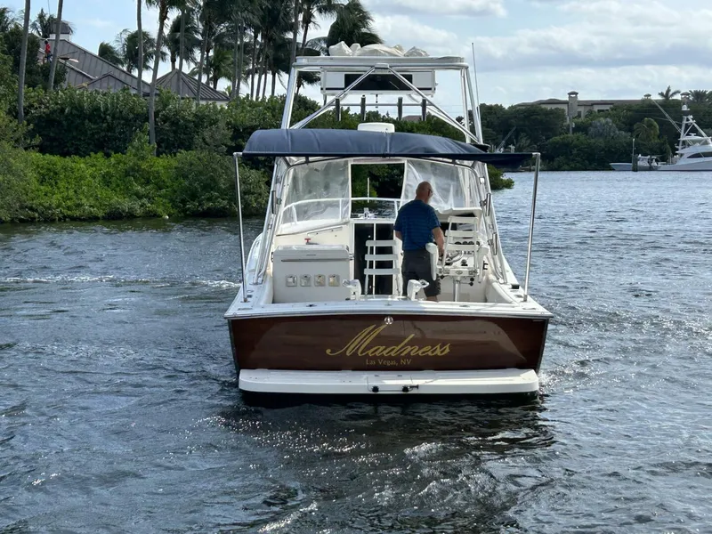 Slide: The Image of 1997 Lazzara Aura Tournament boat named "Madness" cruising on a scenic waterway. - 3