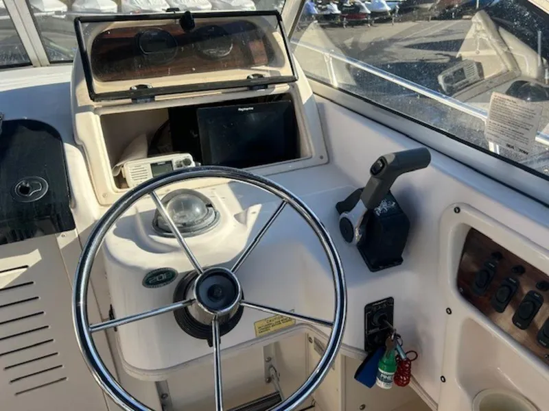Slide: The Image of Grady-White 202 Adventure 2000 boat dashboard with steering wheel and controls. - 13