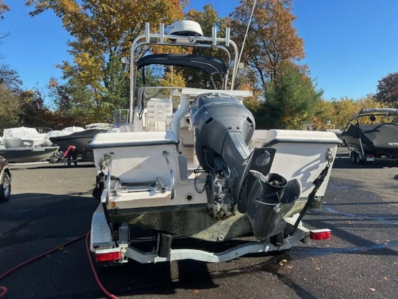 Slide: The Image of Grady-White 202 Adventure 2000 boat with outboard motor, parked outdoors on a sunny day. - 14