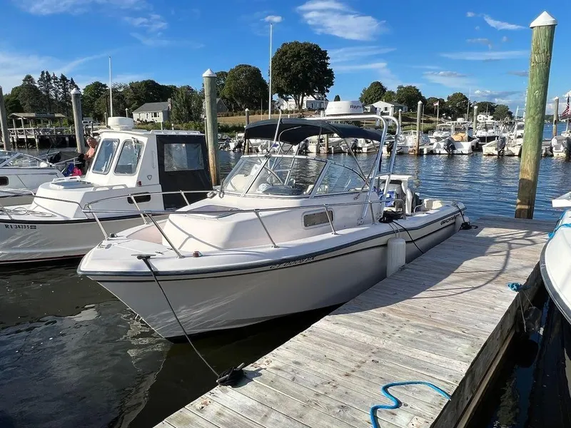 Slide: The Image of 2000 Grady-White 202 Adventure boat docked in a marina under a clear blue sky. - 3