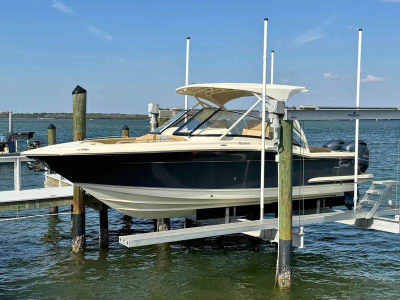 The Image of 2021 Scout 255 Dorado boat on calm blue water under clear sky. - 0
