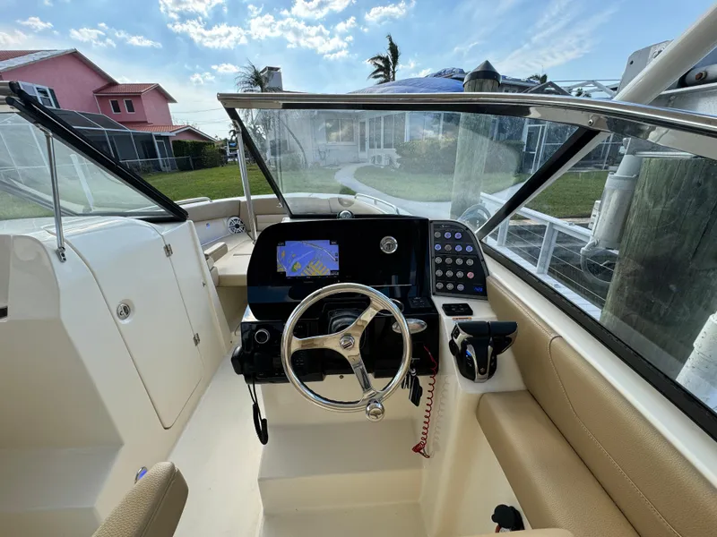 Slide: The Image of 2021 Scout 255 Dorado boat on lift by the water. - 12