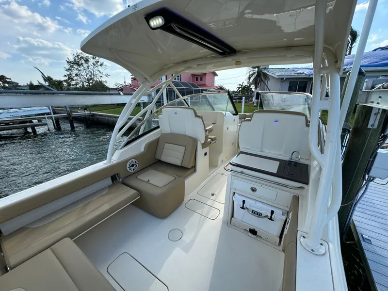 Slide: The Image of 2021 Scout 255 Dorado boat docked at a marina under a clear sky. - 14
