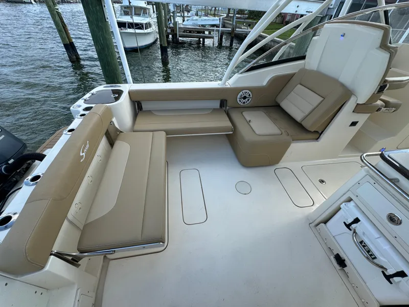 Slide: The Image of 2021 Scout 255 Dorado boat with twin Yamaha outboard motors docked by the water. - 17