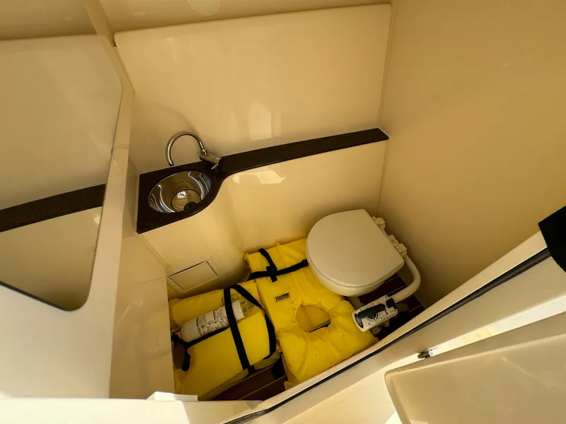 Slide: The Image of 2021 Scout 255 Dorado boat interior with helm and seating, docked by the water. - 22