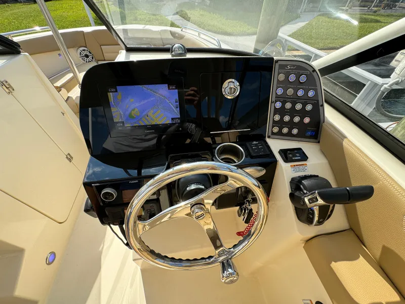 Slide: The Image of 2021 Scout 255 Dorado boat cockpit with steering wheel and navigation system. - 24