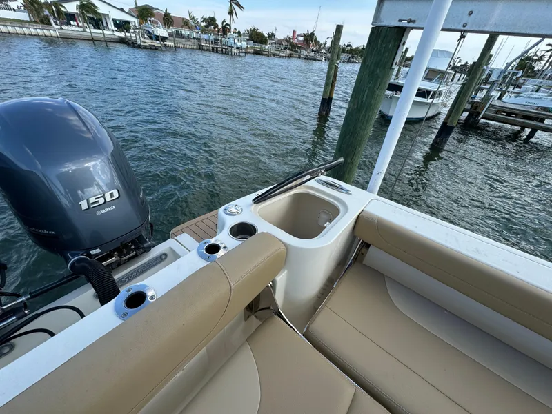 Slide: The Image of 2021 Scout 255 Dorado boat with Yamaha 150 engine, docked by the water. - 31