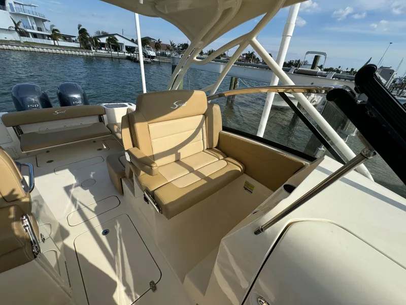 Slide: The Image of 2021 Scout 255 Dorado boat on calm water, with palm trees in the background. - 8