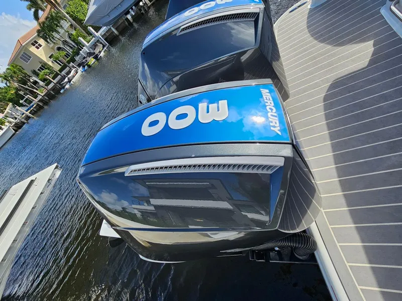 Slide: The Image of 2023 Formula 350 Crossover Bowrider with Mercury outboard engines docked by the water. - 13