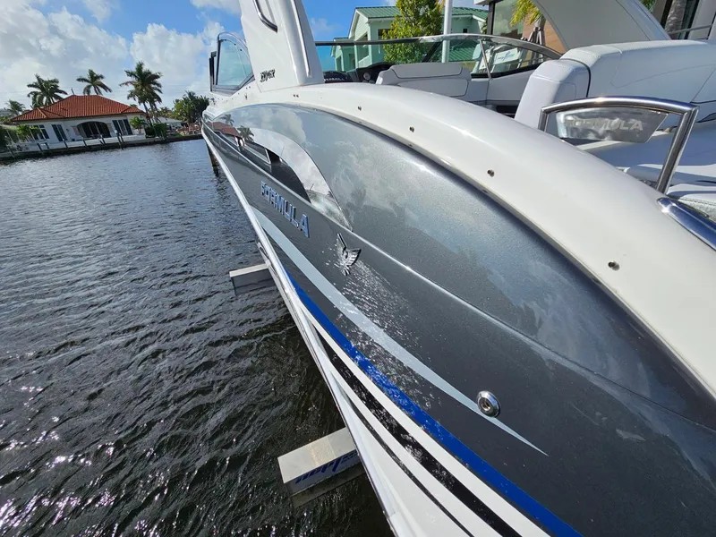 Slide: The Image of 2023 Formula 350 Crossover Bowrider on water, sleek design, sunny day, waterfront view. - 15
