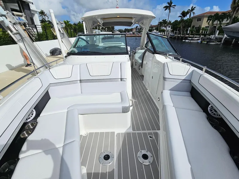 Slide: The Image of 2023 Formula 350 Crossover Bowrider, luxurious seating, sleek design, docked by waterfront homes. - 38