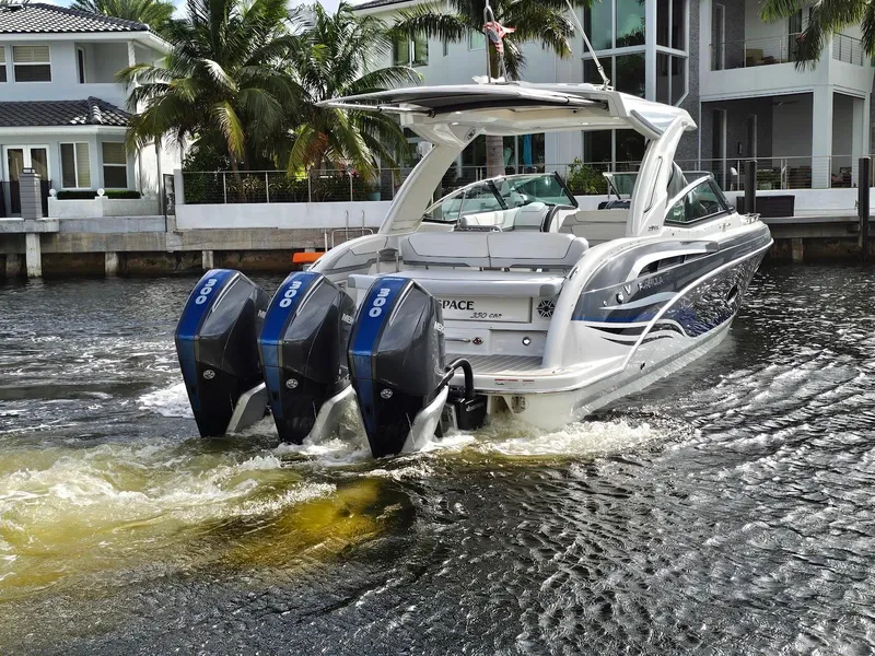Slide: The Image of 2023 Formula 350 Crossover Bowrider cruising on a canal near waterfront homes. - 4