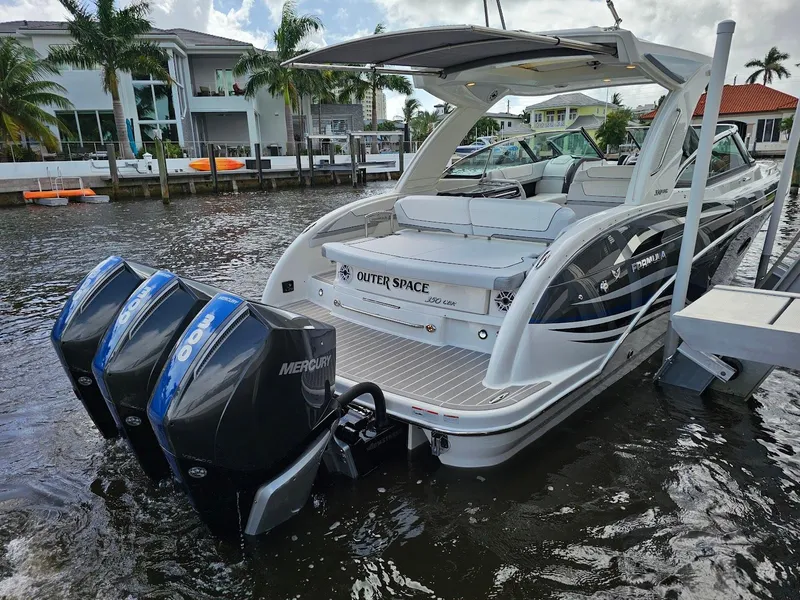 Slide: The Image of 2023 Formula 350 Crossover Bowrider with triple Mercury engines docked by waterfront homes. - 7