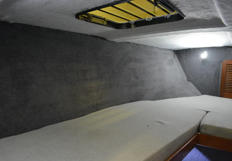 Slide: The Image of Interior cabin of 1980 Sutphen 30 Oceanpacer boat, featuring a cushioned sleeping area. - 13