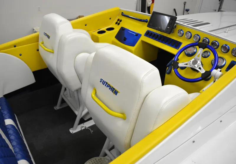 Slide: The Image of 1980 Sutphen 30 Oceanpacer boat interior with yellow and white seating, modern dashboard, and steering wheel. - 3