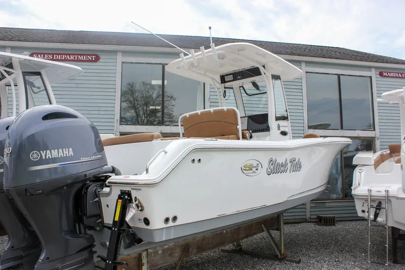 Slide: The Image of 2021 Sea Hunt Ultra 265 SE boat with Yamaha engine, displayed outside a sales department. - 0