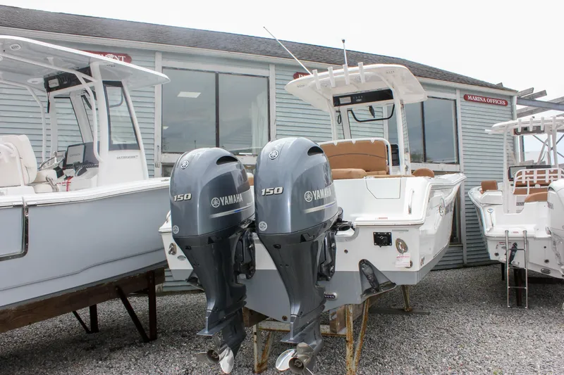 Slide: The Image of 2021 Sea Hunt Ultra 265 SE boat with twin Yamaha 150 engines displayed outdoors. - 1