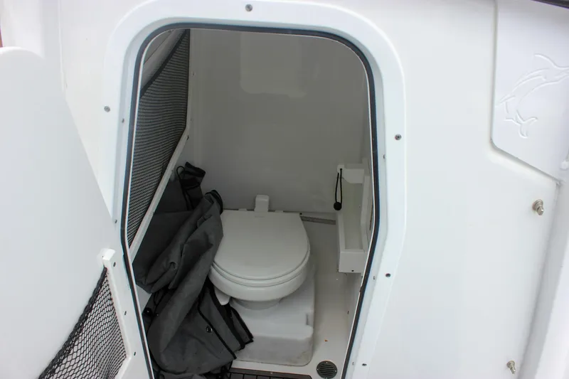 Slide: The Image of 2021 Sea Hunt Ultra 265 SE boat interior with compact marine toilet. - 16