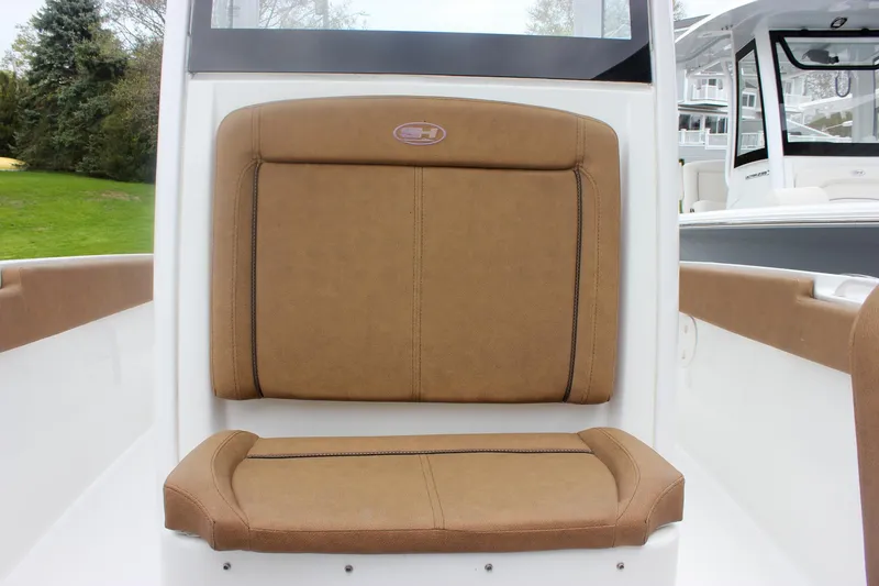Slide: The Image of 2021 Sea Hunt Ultra 265 SE boat seat with brown cushions and white frame. - 18