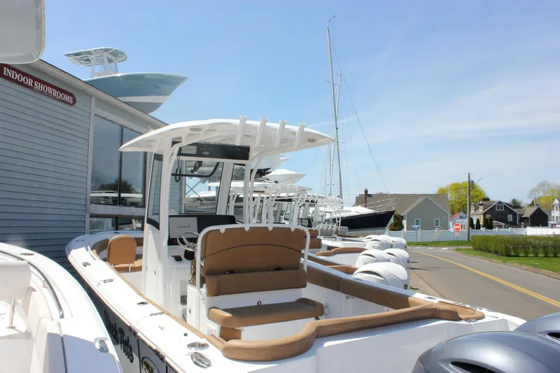 Slide: The Image of 2021 Sea Hunt Ultra 265 SE boat displayed outdoors near showroom. - 2