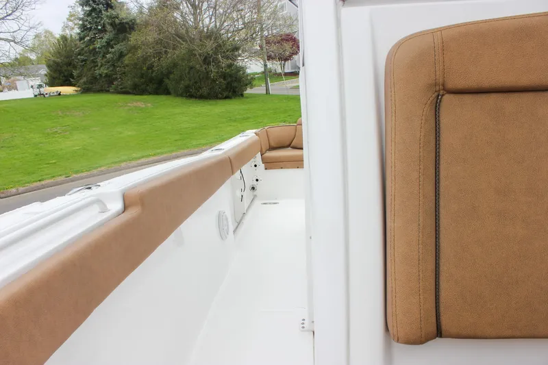 Slide: The Image of 2021 Sea Hunt Ultra 265 SE boat interior with tan seating and white deck. - 20