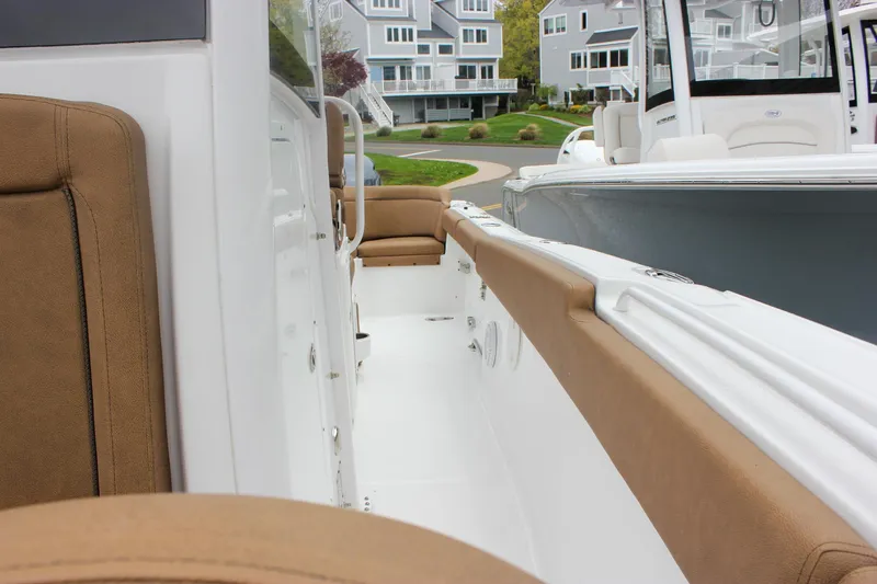 Slide: The Image of 2021 Sea Hunt Ultra 265 SE boat interior with tan seating and white deck. - 21