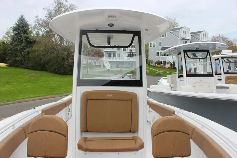 Slide: The Image of 2021 Sea Hunt Ultra 265 SE boat with tan seating, docked near residential area. - 24