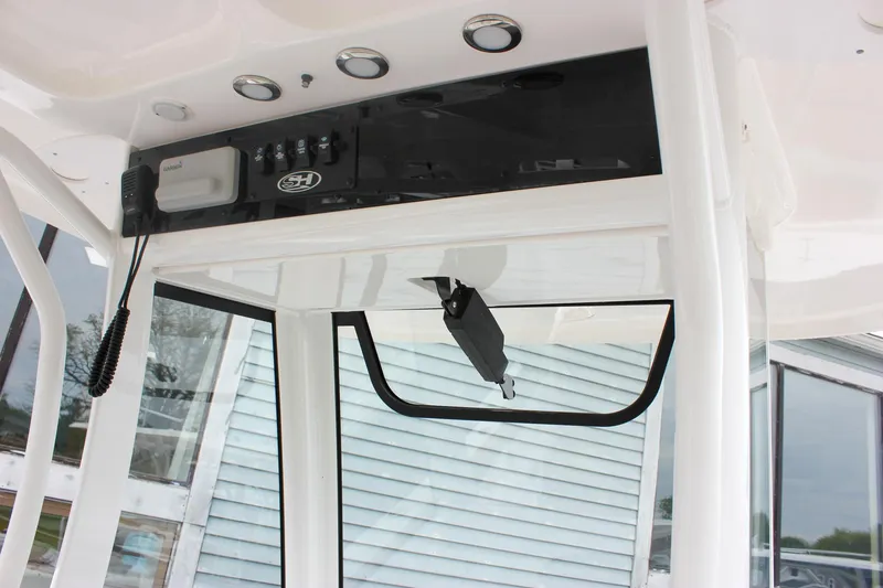 Slide: The Image of 2021 Sea Hunt Ultra 265 SE boat console with controls and storage compartment. - 26