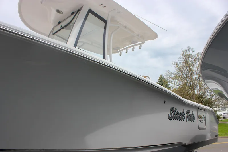 Slide: The Image of 2021 Sea Hunt Ultra 265 SE boat, sleek design, side view, overcast sky. - 33
