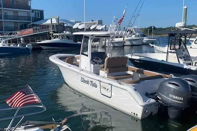Slide: The Image of 2021 Sea Hunt Ultra 265 SE boat docked in marina with twin Yamaha engines. - 38