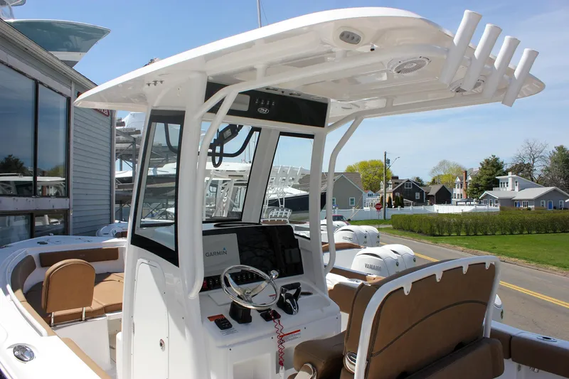 Slide: The Image of 2021 Sea Hunt Ultra 265 SE boat with modern helm and seating, docked near a marina. - 7